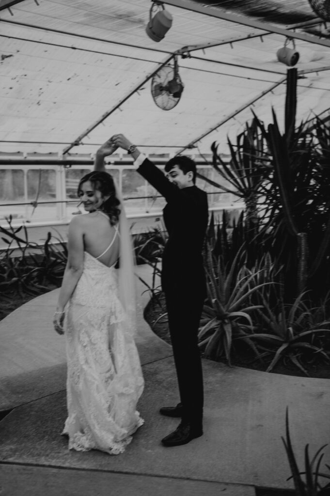 A wedding couple is dancing in a southwestern greenhouse intimate celebration.