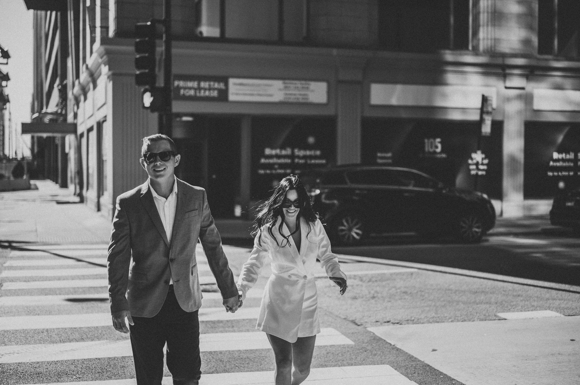 Couple in crosswalk downtown chicago holding hands and laughing