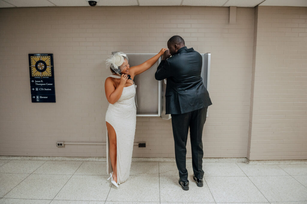 Bride and groom using vintage payphone after Chicago City Hall elopement