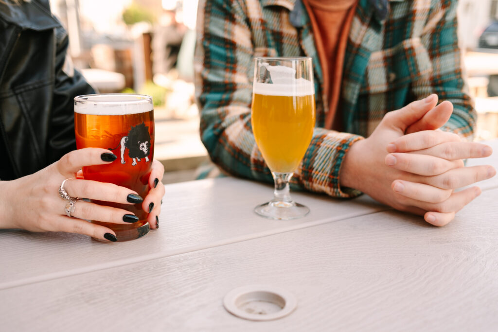 couple drinks beers on engagement shoot